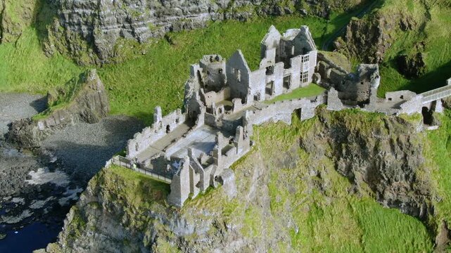 Medieval Dunluce Castle ruin perched on a dramatic cliff in Ireland, revealing the ancient stone fortress on the Antrim Coast