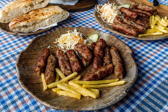 Enjoying cevapi with fries and salad at a local restaurant on a sunny day