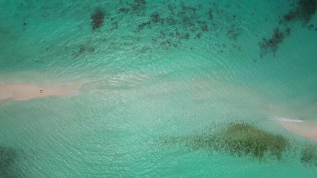 Mesmerizing top-down timelapse showing cloud shadows moving over the pristine, shallow sandy patterns of a remote Caribbean paradise.