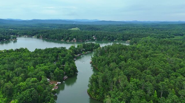 4K drone footage of dense green forests surrounding the calm waters of Lake Cherokee in South Carolina, United States of America.