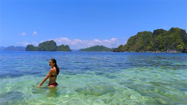 Model released woman turning in clear tropical water near El Nido islands