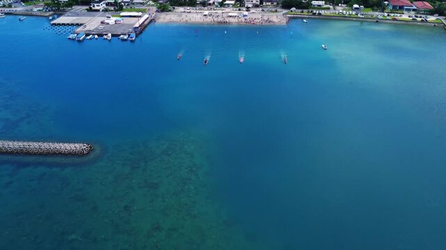 Aerial Drone View of Traditional Boat Race on Blue Ocean with Harbor Town in Okinawa