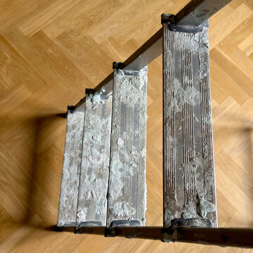 Top down view of Paint-Stained Step Ladder on Oak Parquet Floor