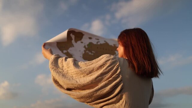Woman raises a world map toward the sky expressing hope for peace global unity environmental responsibility and a better future for humanity and the planet