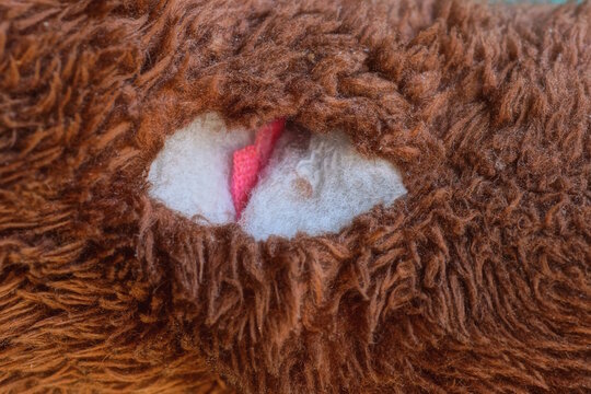fabric texture of torn brown fur with white hole on clothes