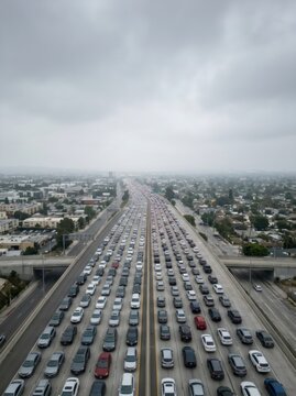 Heavy traffic jam on a busy city highway. Aerial view of cars stuck in a long line on a congested freeway. Urban transportation infrastructure and commuting during rush hour gridlock.