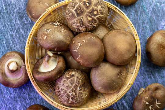 Top view Shiitake mushroom in wooden basket, High-quality culinary ingredient for organic food marketing, gourmet recipes, plant-based diet concepts, and healthy food packaging design.