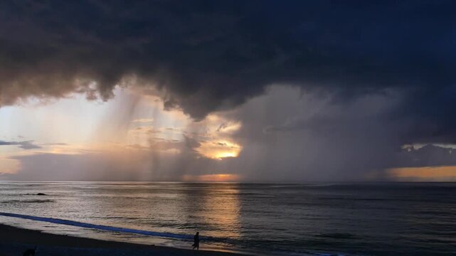 10.05.2026, Erromardie, Frankreich. Mann am Strand bei schlechtem Wetter mit Gewitter und Sonnenuntergang an der K&uuml;ste.