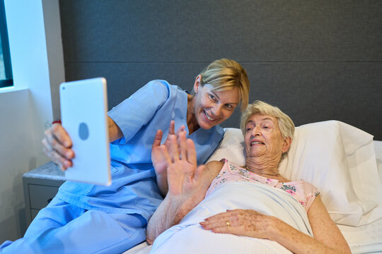 Nurse Helping Elderly Patient Communicate Through Video Call Using a Tablet