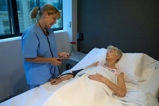 Nurse caring for senior patient in a comfortable healthcare facility room