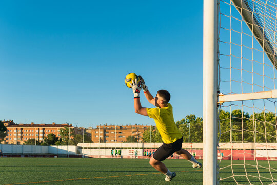 Soccer goalkeeper catching ball and saving goal