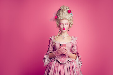 Fototapeta premium Photo of gorgeous pretty lady dressed pompous rococo costume chatting modern device empty space isolated pink color background