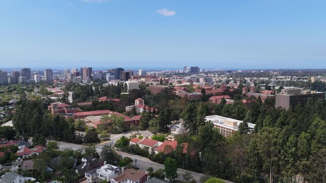 Westwood Los Angeles neighborhood showcasing UCLA campus with downtown buildings, residential homes, and green trees under clear blue sky