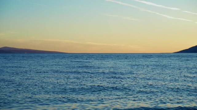 Golden sunset over the Adriatic Sea in Brela, Croatia, featuring calm blue water, warm evening sky and a peaceful Mediterranean seascape on the Croatian coast