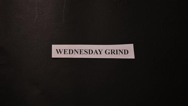 Wednesday Grind Work Focus Concept with Paper Note on Black Texture Surface