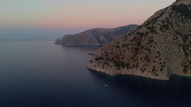 Drone 4k footage capturing the serene morning light over the Aegean Sea and coastline in Symi Island, Greece.