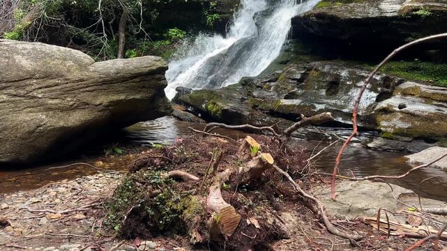 4k Footage of a small waterfall cascading over rocks in the lush green forest of Warwoman Dell in Georgia, USA. Butterflies flying around the shot.