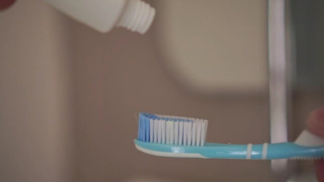 toothpaste squeezed onto a toothbrush for morning dental care. Personal hygiene concept with focus on oral health and cleanliness.