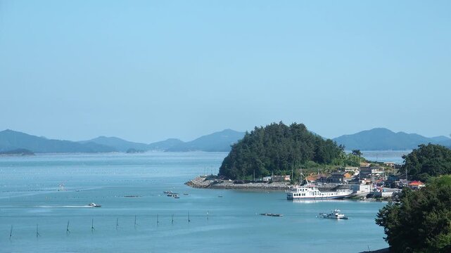 Scenic view of a peaceful Korean southern sea fishing village with local fisherman boats, mudflats, and islands in Namhae / 한국 남해바다 어촌 마을 풍경, 어민들의 고기잡이 배와 평화로운 섬, 갯벌 해안가 풍경 영상