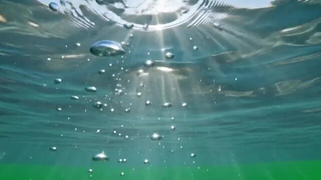 Underwater view with rising air bubbles and shimmering sunlight refraction perspective looking