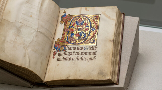 Close up of a large illuminated letter in a medieval codex. Ancient manuscript with gold leaf decoration and gothic script on parchment