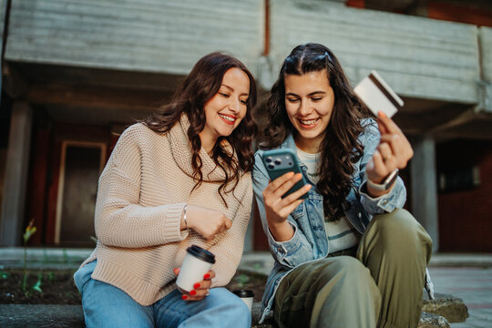 Friends shopping online with smartphone and credit card