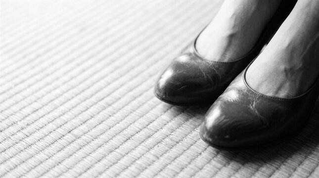 昭和の日本人女性：昭和の映画や文学的なワンシーンをイメージした、古い日本家屋の畳の上でハイヒールを履いて佇む20代日本人女性の足元モノクロクローズアップ