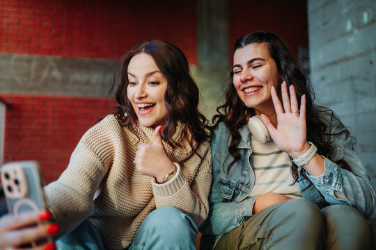 Young women friends having video call with smartphone