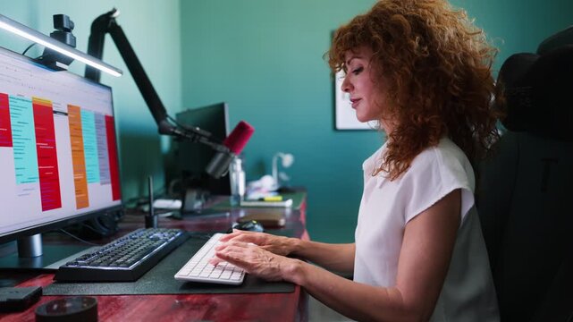 Woman working on computer with microphone and webcam in home office