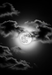 Fototapeta premium Dramatic Full Moon Shining Through Dark Clouds in a Black and White Night Sky Background