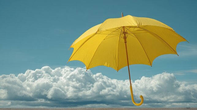 Bright yellow umbrella against vibrant blue sky with fluffy white clouds, cheerful summer weather, minimal outdoor background, sunny day, optimism, travel, seasonal nature and copy space