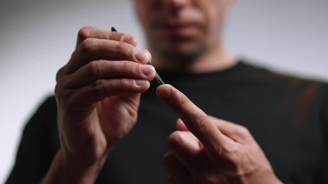 Close up of a man hand extracting a splinter from finger with tweezers