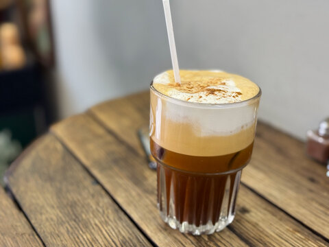 Freddo Cappuccino Greek iced coffee drink with espresso and cold frothy milk on a wooden table close up