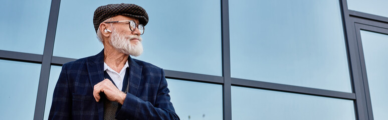 A distinguished older man stands confidently in autumn attire, radiating style against a contemporary backdrop. © LIGHTFIELD STUDIOS