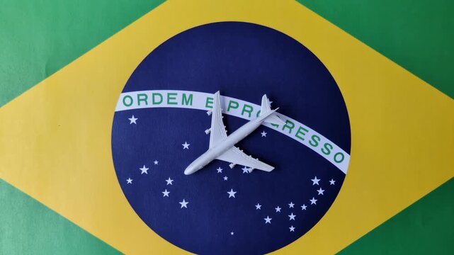 An airplane on the brazil flag as a conceptual backdrop for flights and travel. An airplane on the brazil flag as a background for your design
