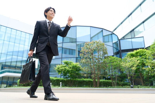 元気にオフィス街を歩くビジネスマン