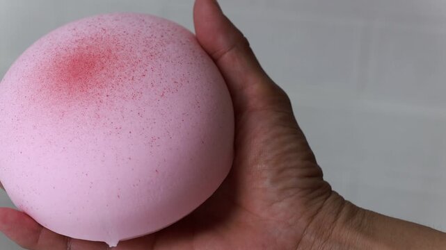 Close-up Hand Squeezing and Releasing a Slow-Motion Squishy Toy