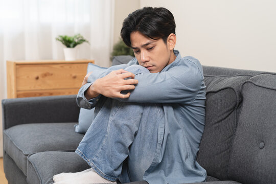 Young man feeling stressed and unhappy while staying alone at home, mental health concept.