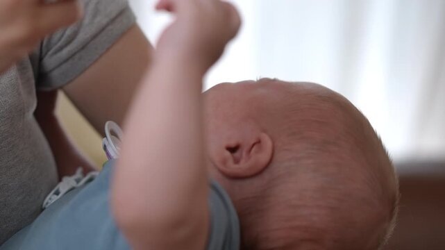 Mother giving newborn baby liquid supplement with a dropper
