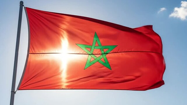 Morocco national flag waving against blue sky with sun