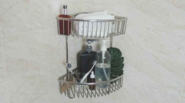 Reducing visual clutter. Shower corner caddy holding dispenser bottles, white rolled towel, toothbrushes, and a tropical leaf in a modern bathroom