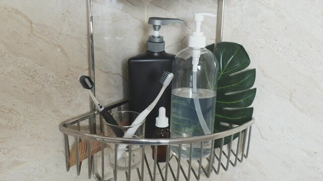 Reducing visual clutter. Bathroom hygiene products, including charcoal toothbrushes, shampoo, and soap dispenser bottles, neatly arranged on a chrome shower shelf