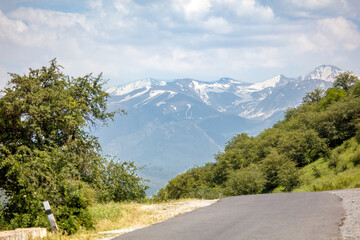 Naklejka premium Asphalt road winds through green hills