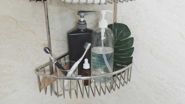 Reducing visual clutter. Bathroom shower caddy holding personal care products, including toothbrushes, soap dispensers, and a plant leaf, highlighting hygiene