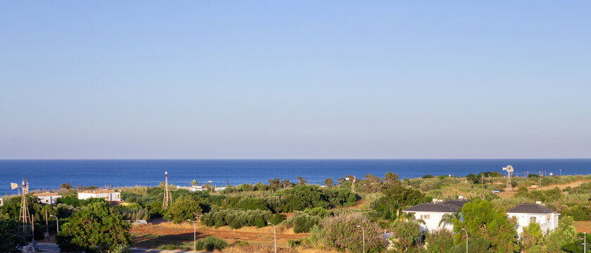 Ultra wide panoramic view of farmland and Mediterranean coastline near Protaras, Cyprus with blue sea, open horizon and natural rural landscape
