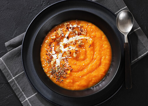 spiced sweet potato soup in a black bowl