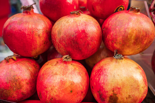 Fresh whole pomegranates displayed at traditional market in Thailand
