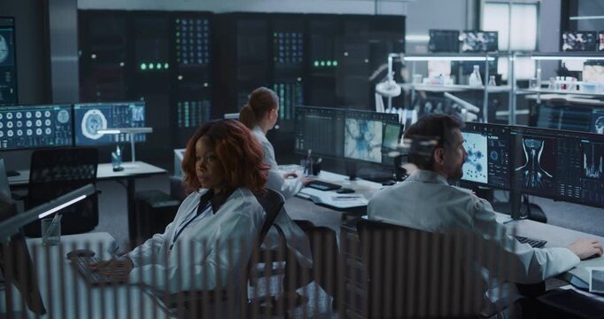 Team of Scientists work on Computers in an Advanced Medical Research Laboratory, Examining Brain Scans, Molecular Structures With AI Technology to Accelerate Drug Development and Disease Treatment.