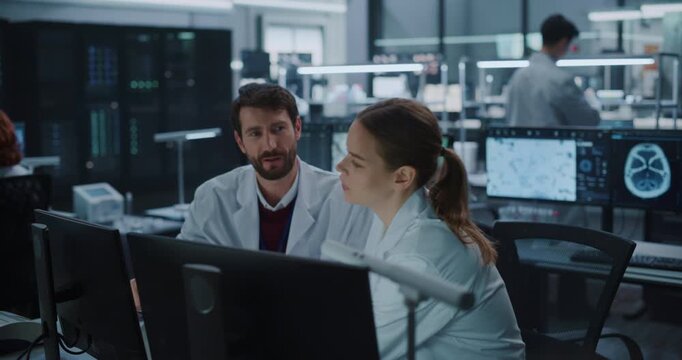 Male and Female Scientists Talk and Point at Computer Monitors Displaying Brain Scans in a Modern Medical Research Laboratory, Using Ai Technology to Advance Neurology Treatment and Drug Development.