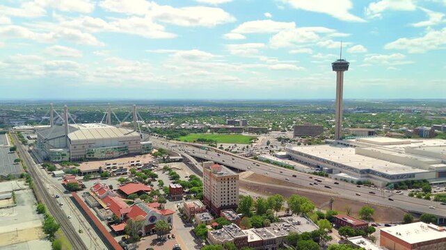 The drone flies steadily forward toward the Tower of the Americas and Alamodome complex below.